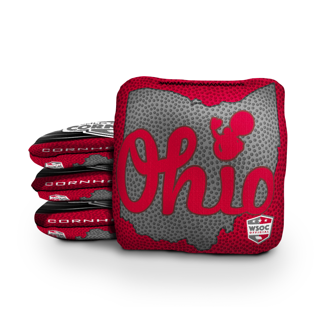 College team cornhole bags beside a regulation board at a game-day tailgate
