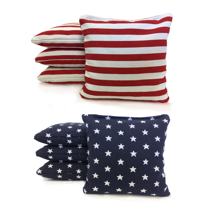 Corn-filled and resin-filled duck cloth cornhole bags in contrasting colors beside a regulation board
