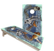 Hunting and fishing cornhole boards with bass, deer and camouflage designs at an outdoor cabin
